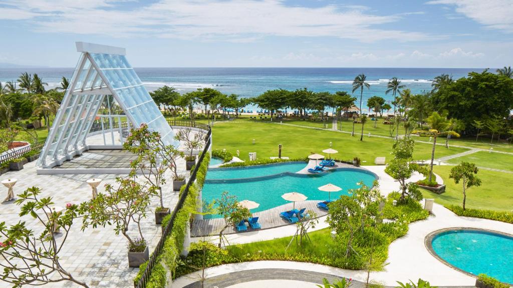 an aerial view of a resort with a swimming pool and the ocean at MERUSAKA Nusa Dua in Nusa Dua