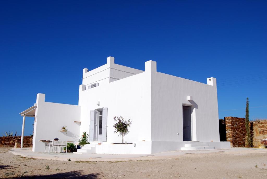 a white house with a blue sky in the background at Ios art villa in Ios Chora