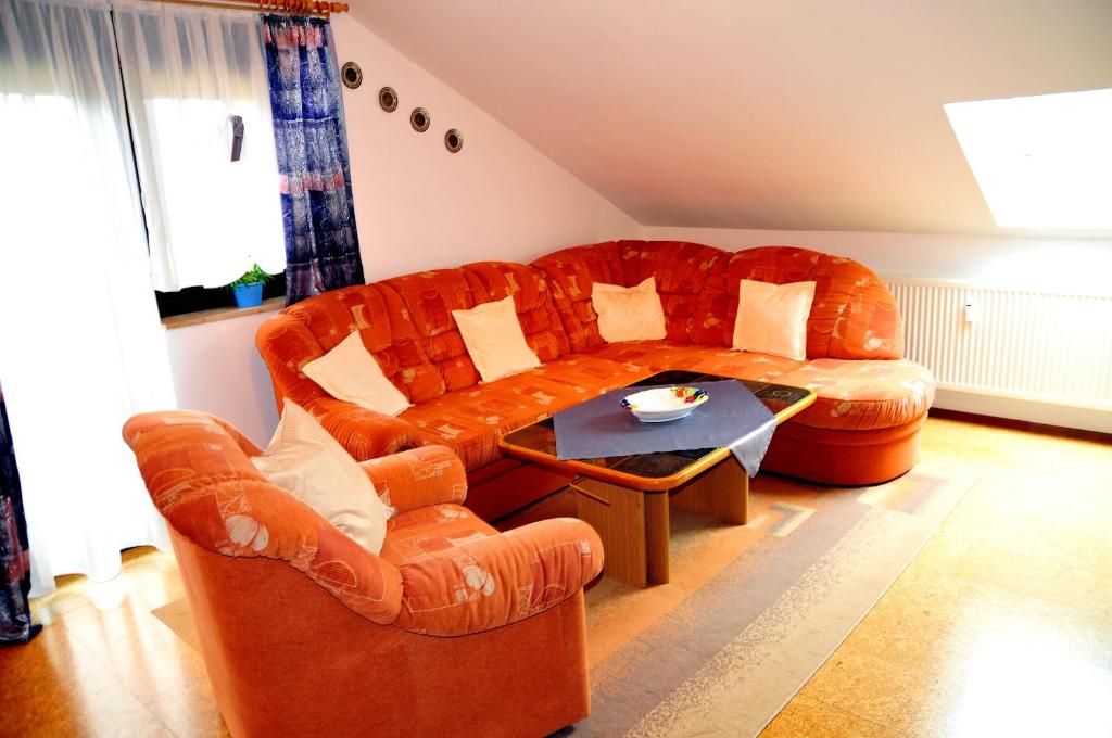a living room with an orange couch and a table at Ferienwohnung Werner in Warmensteinach