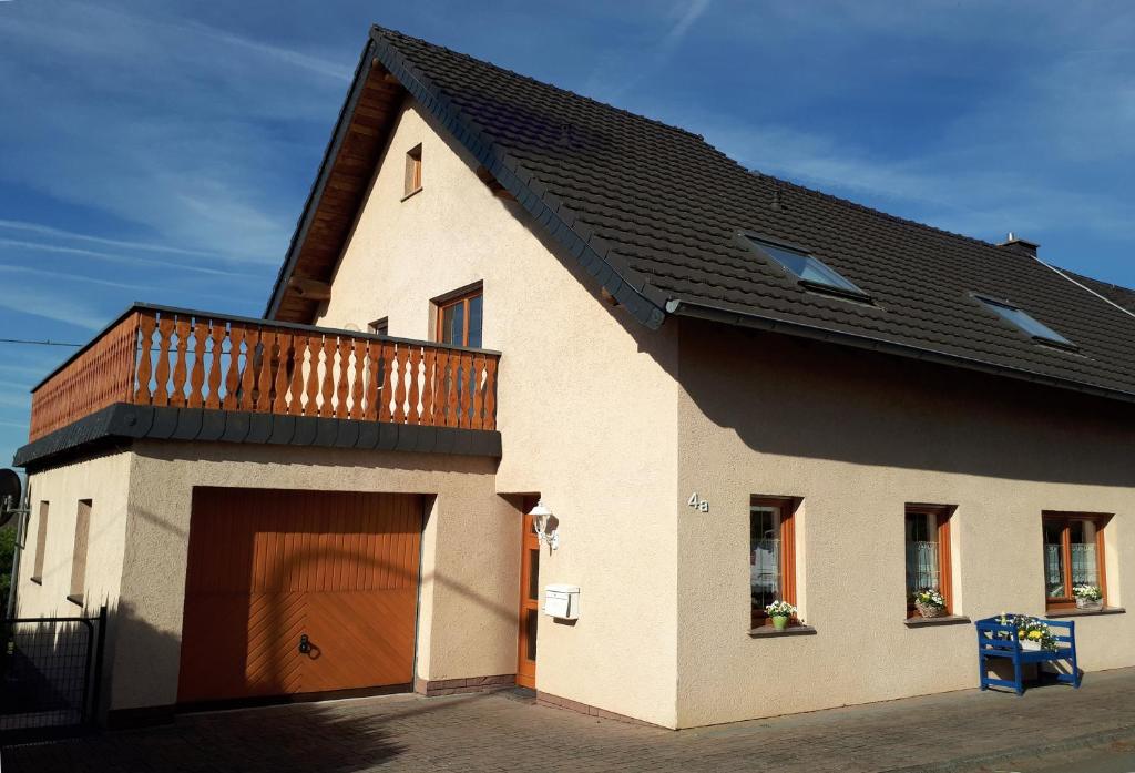 une maison avec une porte de garage en bois et un balcon dans l'établissement Eifelferienhaus Pruem, à Steinmehlen