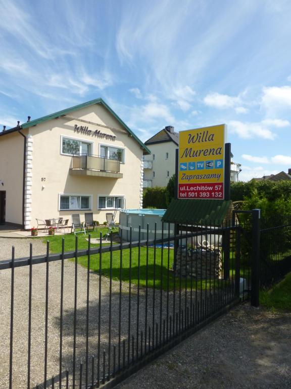 a sign on a fence in front of a house at Willa Murena in Mielno