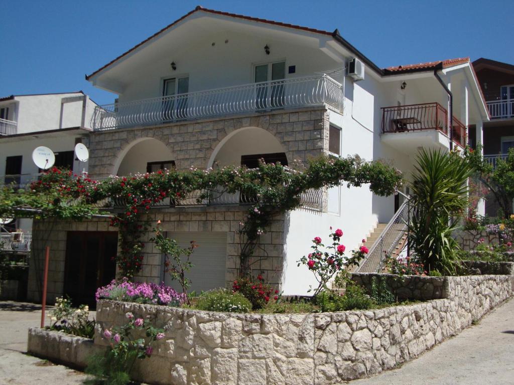 a house with flowers in front of it at Apartments Marinovic Baćina Lakes in Ploče