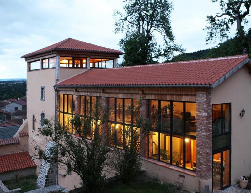 a large house with large windows on the side of it at Domaine Saint-Roch Hotel Spa in Salzuit