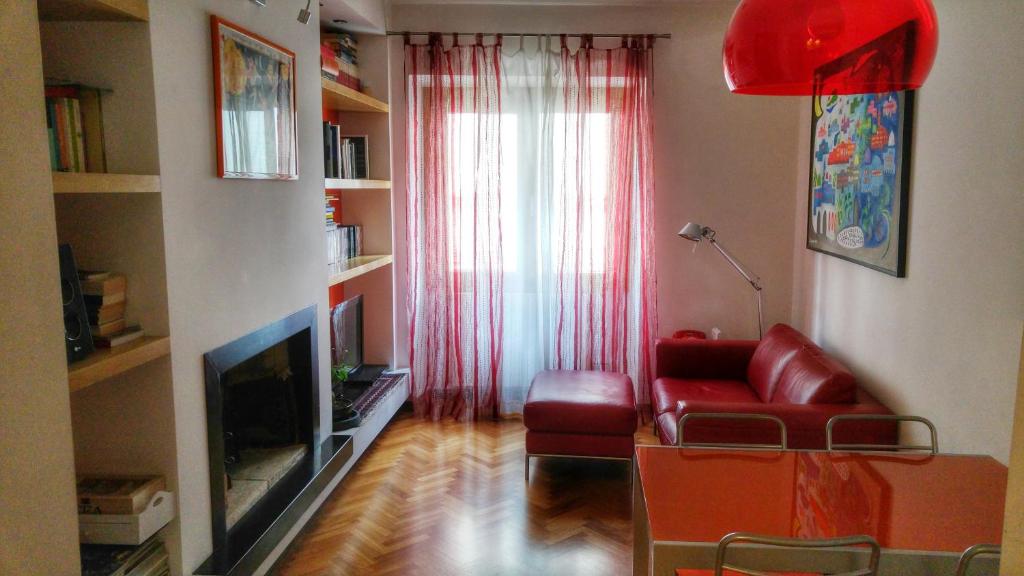 un soggiorno con divano rosso e TV di La Ciammarica a Sulmona
