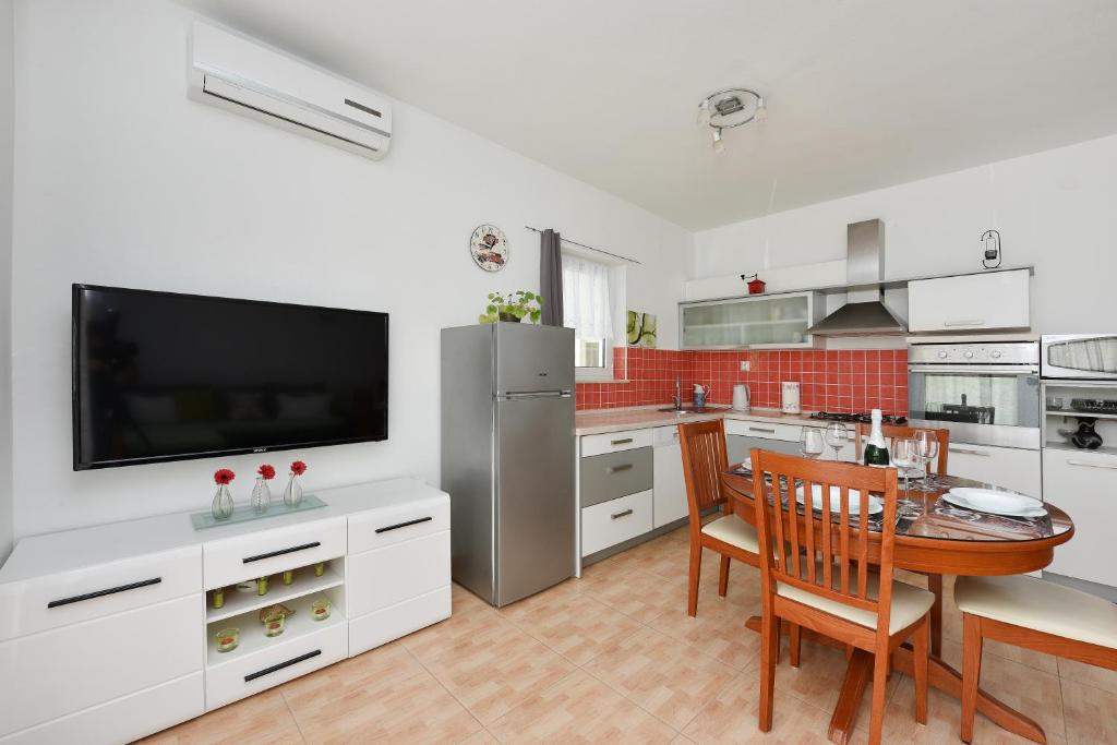 cocina con mesa de comedor y TV en DS Apartments, en Vodice