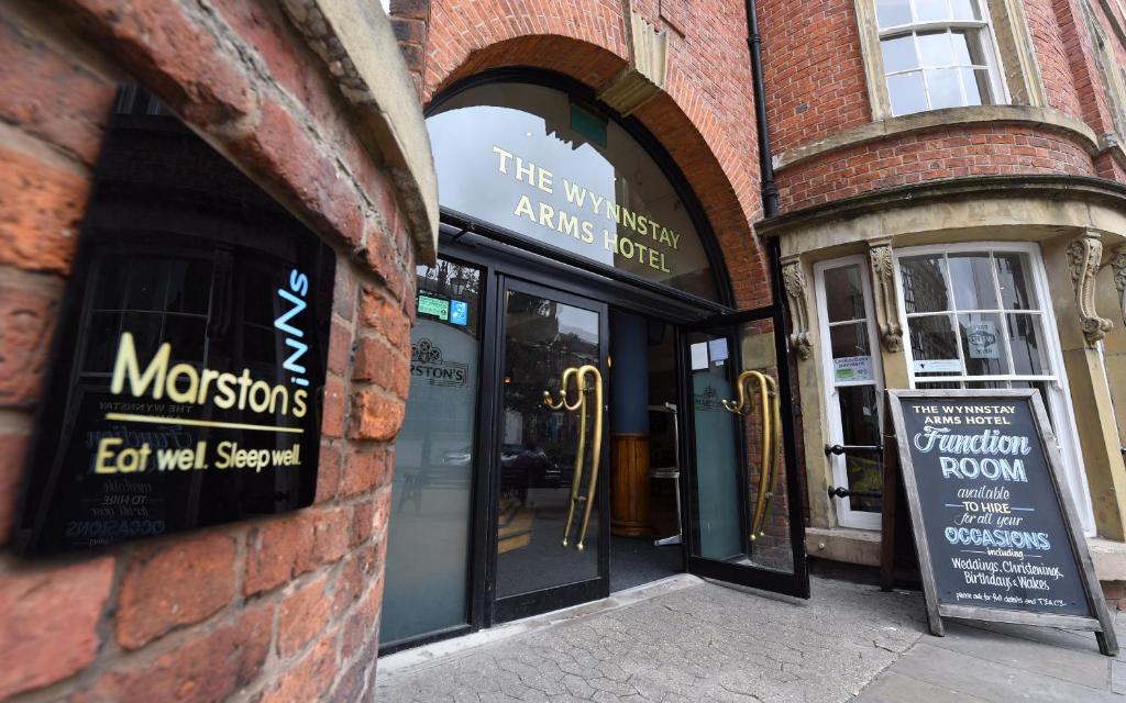 a brick building with the entrance to a store at Wynnstay Arms, Wrexham by Marston's Inns in Wrexham