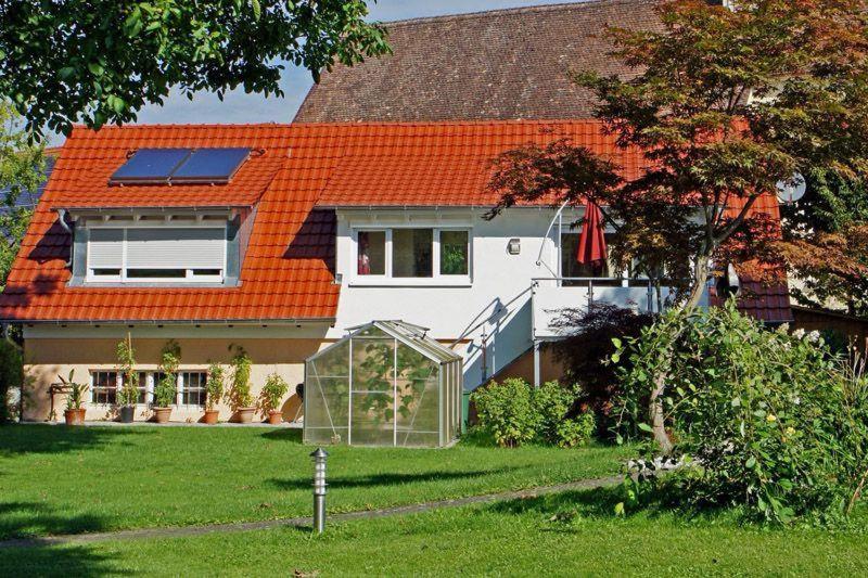 a house with an orange roof with a yard at Haus-Eiche in Überlingen