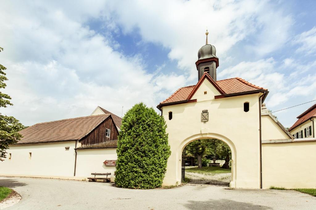 una iglesia blanca con un arco y un campanario en Hotel & Reitsportzentrum Kreuth, en Heideck