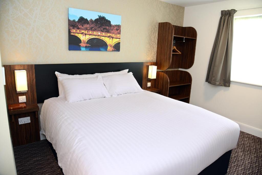 a bedroom with a white bed and a bridge at Blue Jay, Derby by Marston's Inns in Derby