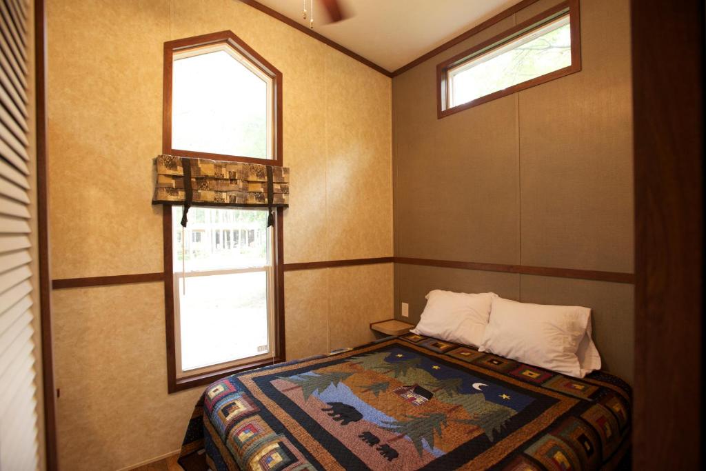a bedroom with two windows and a bed in it at Yukon Trails Camping Resort in Lyndon Station