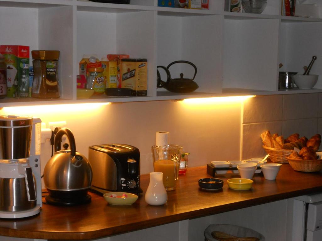 a kitchen counter with a coffee maker and some food at La Maison Du Coteau in Cachan