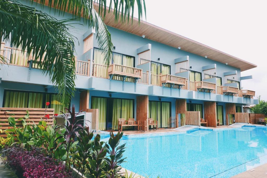 un hotel con piscina frente a un edificio en Le Pes Villas, en Khanom