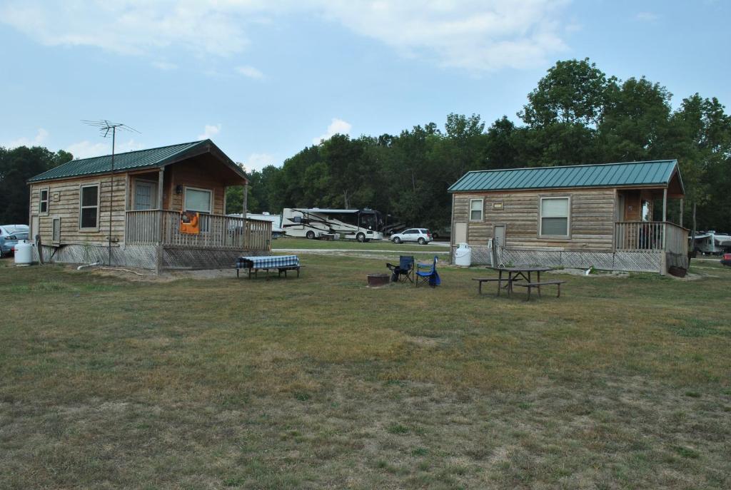 a log cabin with a picnic table and a house at Wilmington Camping Resort in Wilmington