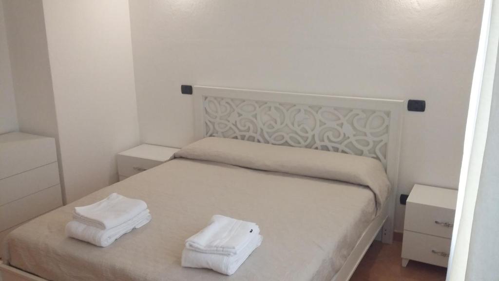 ein Schlafzimmer mit einem Bett mit zwei Handtüchern darauf in der Unterkunft Don Diego Apartment Orosei in Orosei