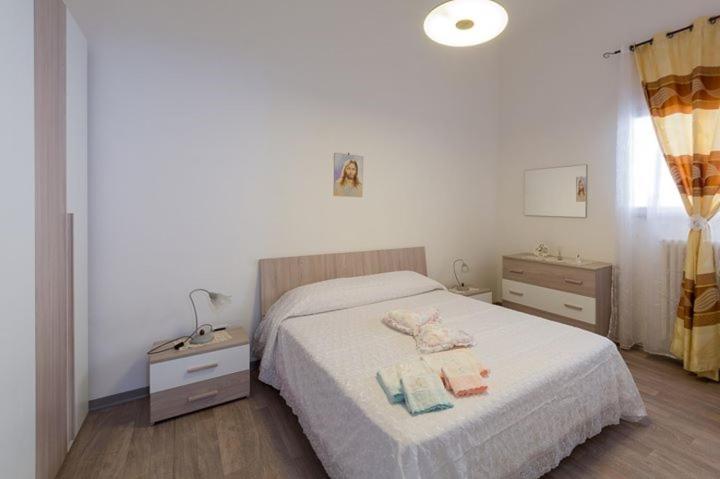 ein Schlafzimmer mit einem Bett und zwei Nachttischen mit Handtüchern darauf in der Unterkunft Casa vacanza Simone in Andria