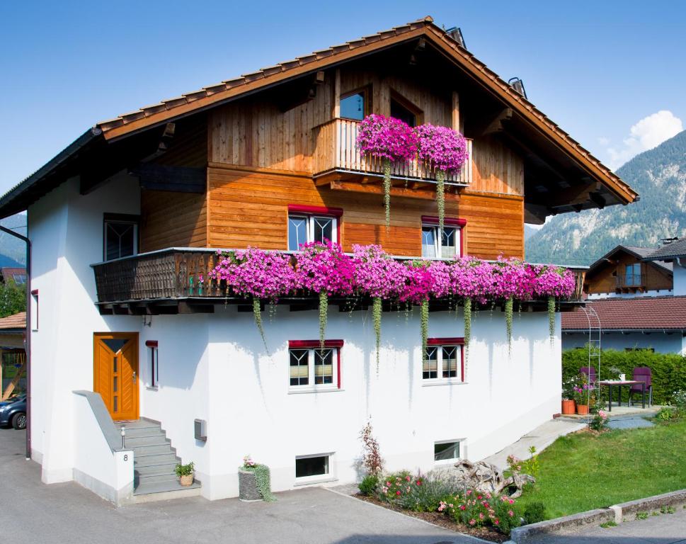 ein Haus mit lila Blumen auf der Seite in der Unterkunft Apartments Schöll in Reutte