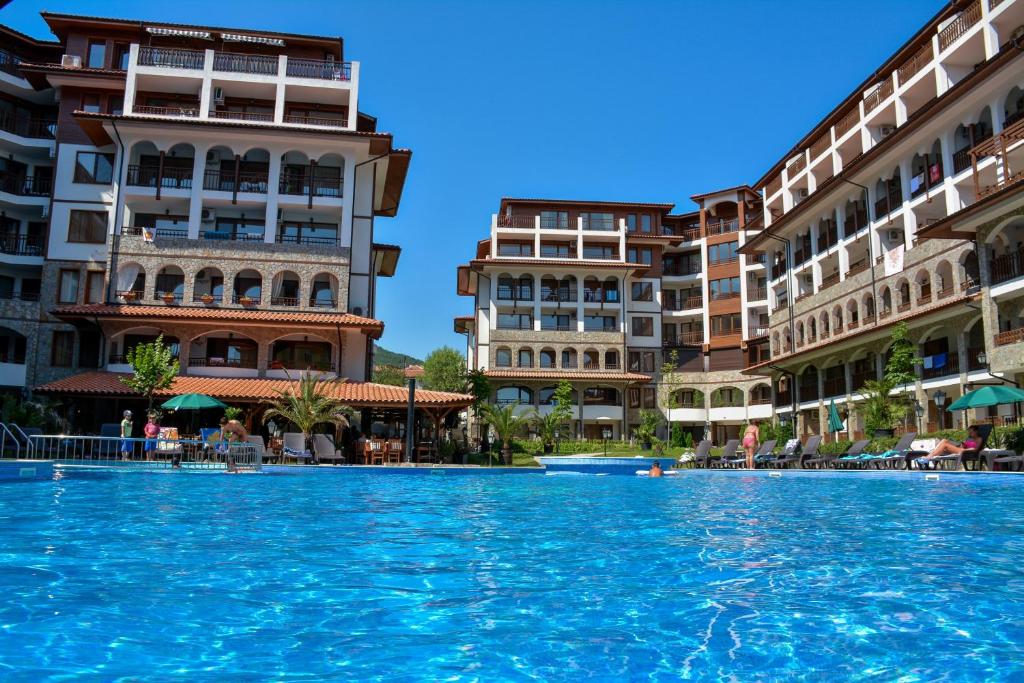 a swimming pool in the middle of two buildings at OLYMP Aparthotel in Sveti Vlas
