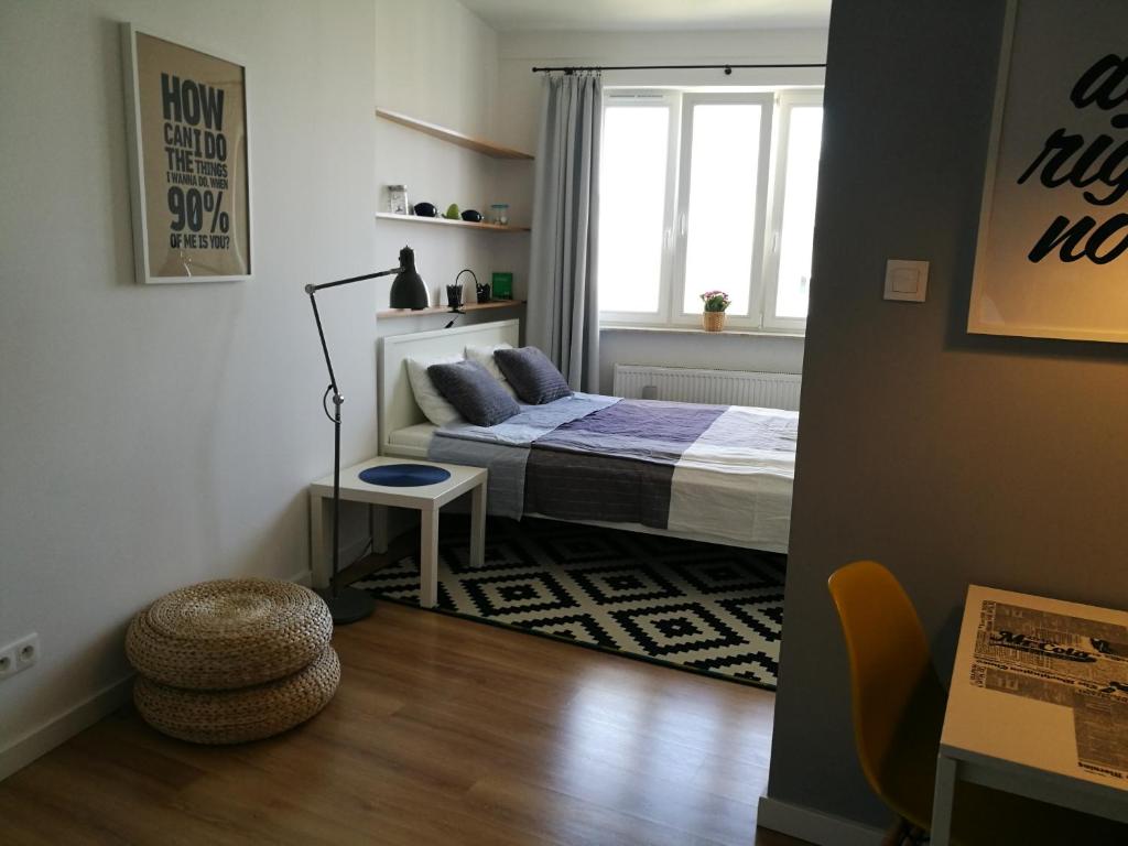niewielka sypialnia z łóżkiem i oknem w obiekcie Apartament blisko Centrum w Warszawie