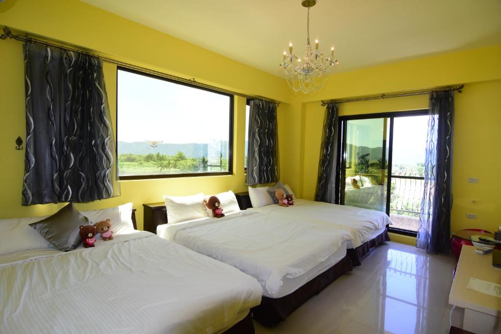 a bedroom with two beds with teddy bears on them at Xinyue B&amp;B in Fenglin