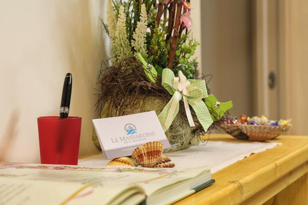 un tavolo con una carta e un vaso di fiori di Le mansardine a Vasto