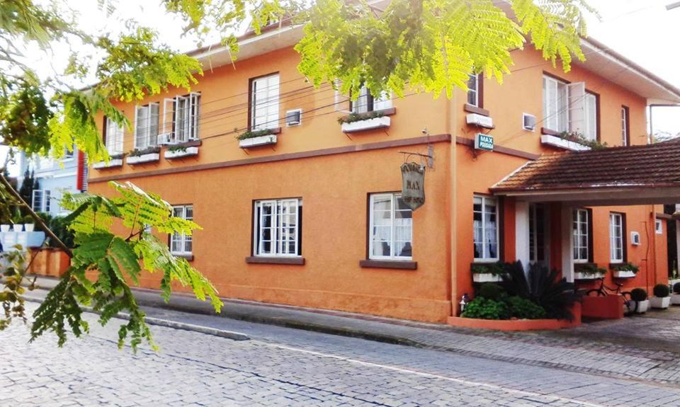 a orange building with windows on a street at Pousada Max Pomerode in Pomerode