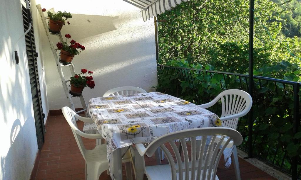 Casa sul bosco في Roa Marenca: طاولة وكراسي بيضاء على شرفة