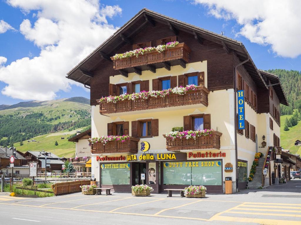 a building with flower boxes on the side of it at Hotel Baita della Luna in Livigno
