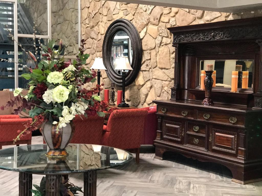 a living room with a table and a mirror at Hub City Inn in Lubbock