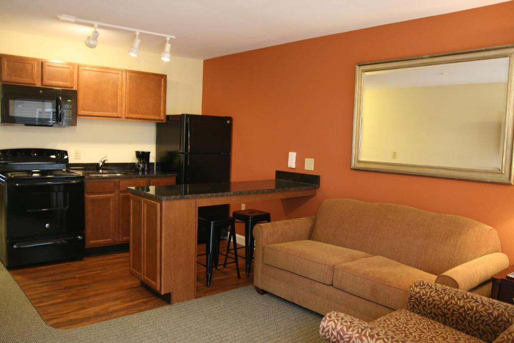 a living room with a couch and a kitchen at Affordable Suites Mooresville in Mooresville