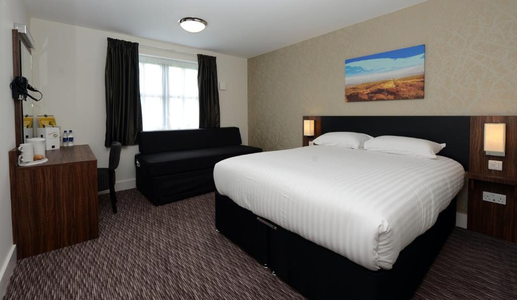 ein Hotelzimmer mit einem Bett und einem Stuhl in der Unterkunft Fallow Field, Telford by Marston's Inns in Telford