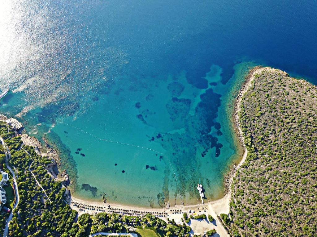 an aerial view of a beach with turquoise water at Kempinski Hotel Barbaros Bay Bodrum in Yaliciftlik