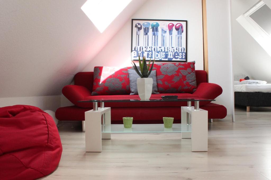 a living room with a red couch and a table at Ferienwohnung Fulda in Fulda