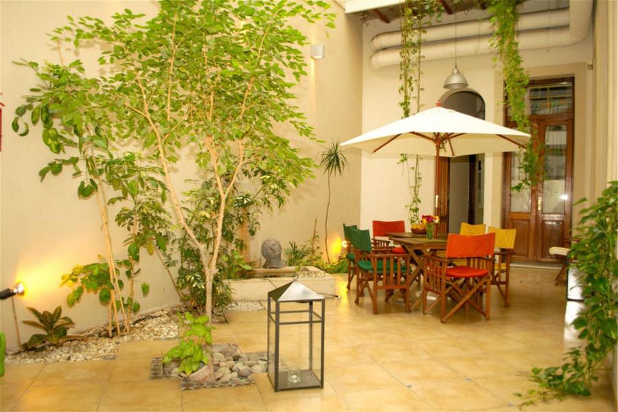 a patio with a table and chairs and an umbrella at La Casona del Alma in Buenos Aires