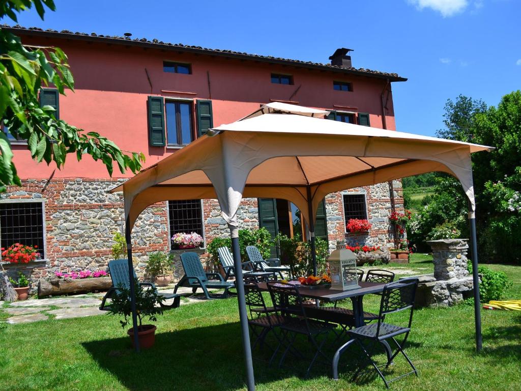 una mesa con sombrilla frente a una casa en Independent Tuscan Holiday Home with Garden and Valley views, en Pieve Fosciana