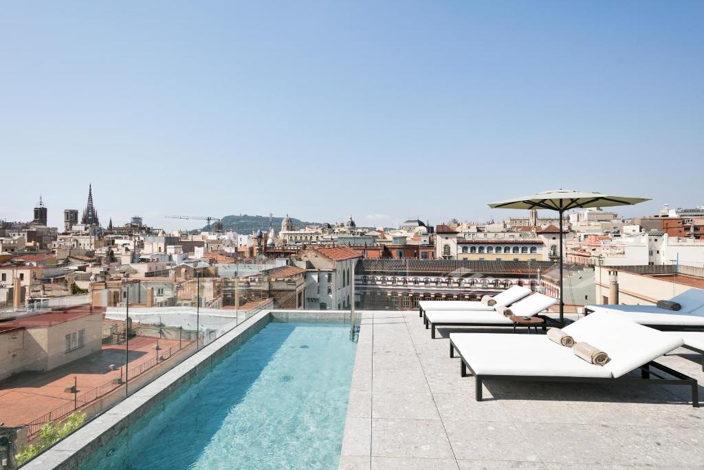 a patio area with a balcony overlooking a city at Yurbban Passage Hotel & Spa in Barcelona