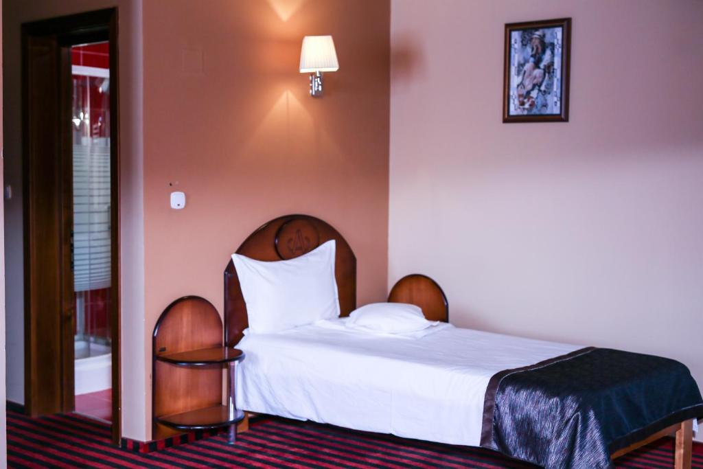 a hotel room with a bed and two chairs at Hotel Atlantic in Adjud