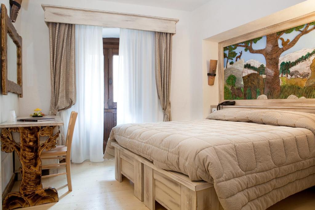 a bedroom with a bed and a large window at Garnì La Rua nel Bosco in Rivisondoli