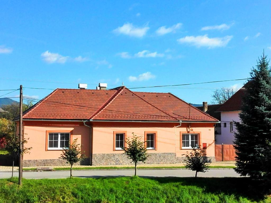 una casa con techo rojo en una calle en Ubytovanie Betty, en Krásnohorské Podhradie