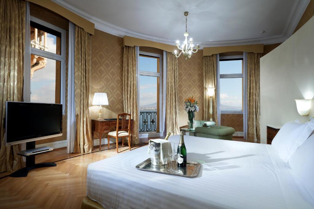 a hotel room with a large bed and a television at Eurostars Hotel Excelsior in Naples