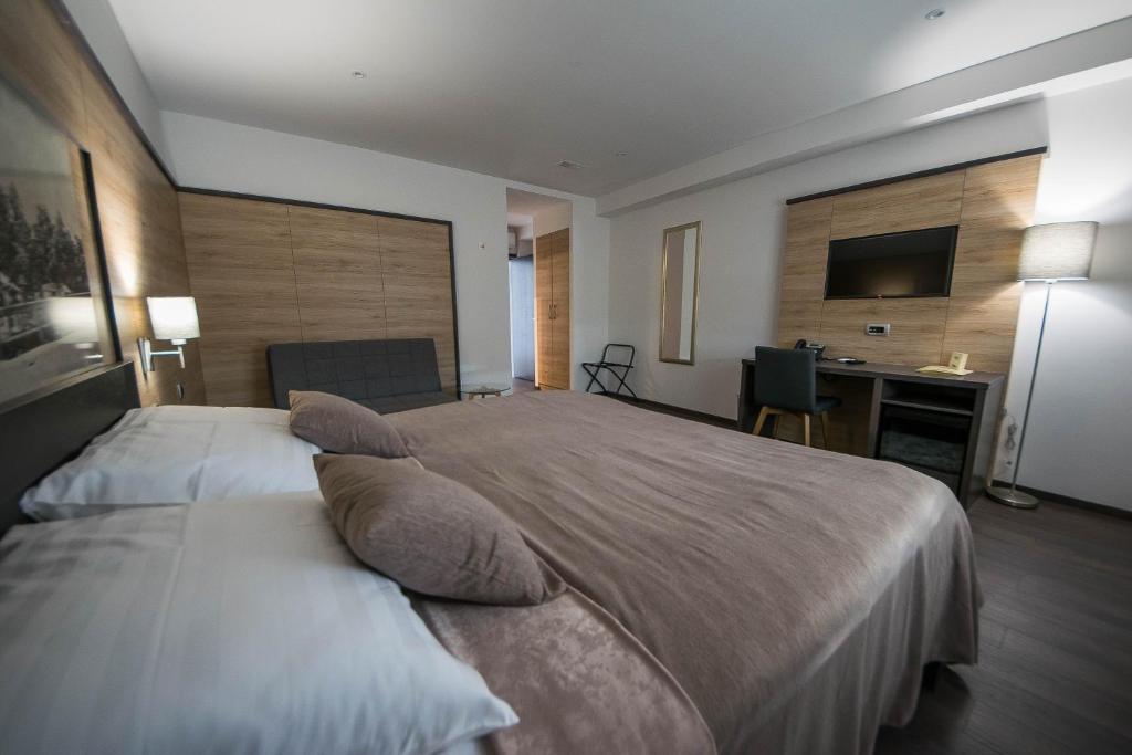 sypialnia z dużym łóżkiem z poduszkami i biurkiem w obiekcie Rooms The King's Pub w mieście Kutina