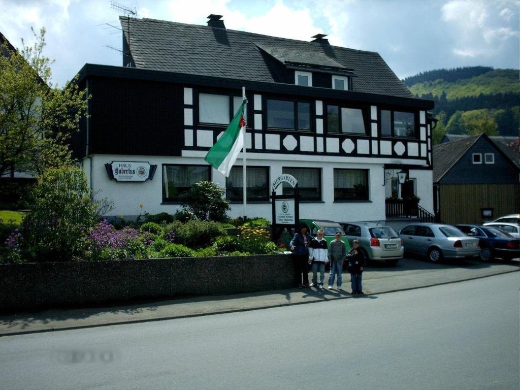 um grupo de pessoas em pé em frente a uma casa em Gasthof Haus Hubertus em Winterberg