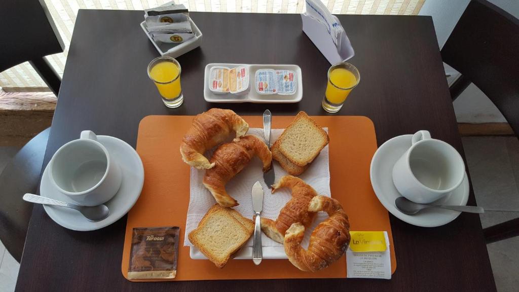 una mesa con una bandeja de cruasanes y pan en Antigua Fonda Hosteria en Concepción del Uruguay