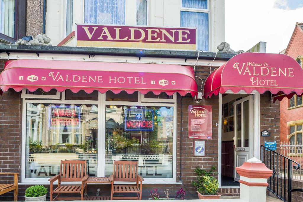 ブラックプールにあるValdene Hotelの建物の前にテーブルと椅子が2脚あるレストラン