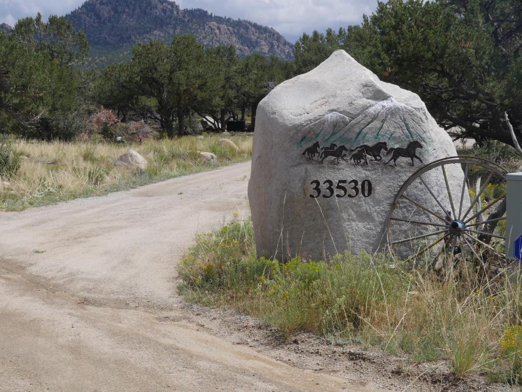 uma rocha com um sinal no lado de uma estrada em Five Peaks em Buena Vista