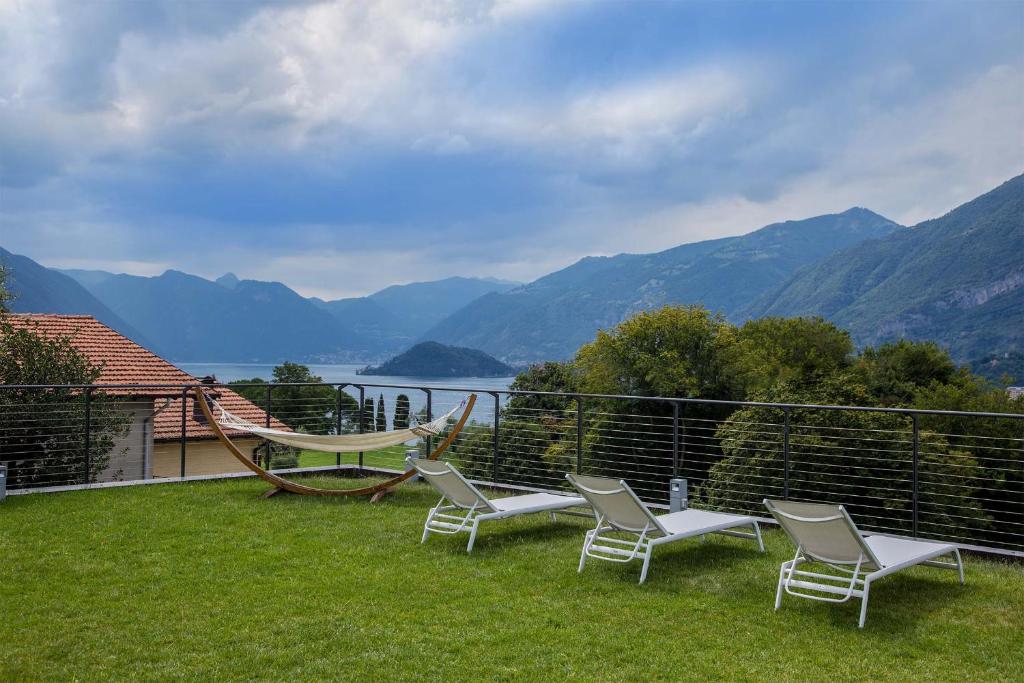 a patio with chairs and a hammock on the grass at Villa La Rosa B&B in Bellagio