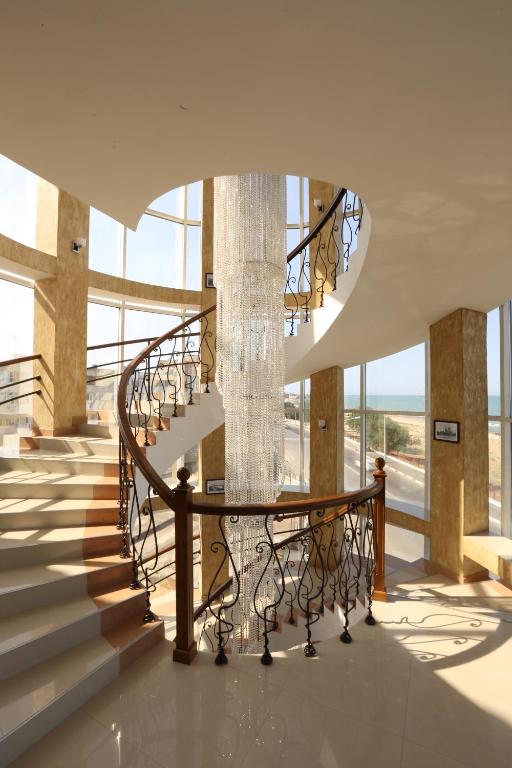 a staircase in a building with a chandelier at Hotel Metropol in Derbent