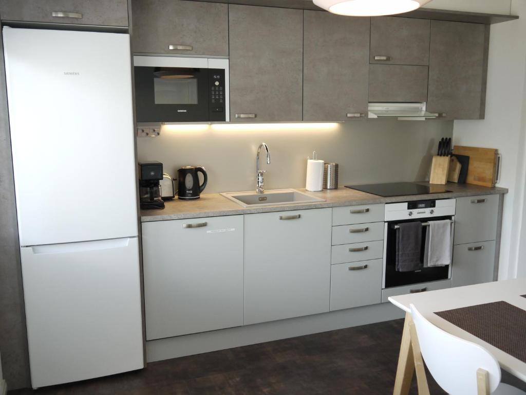a kitchen with white cabinets and a sink at Apartment Skylights in Rovaniemi