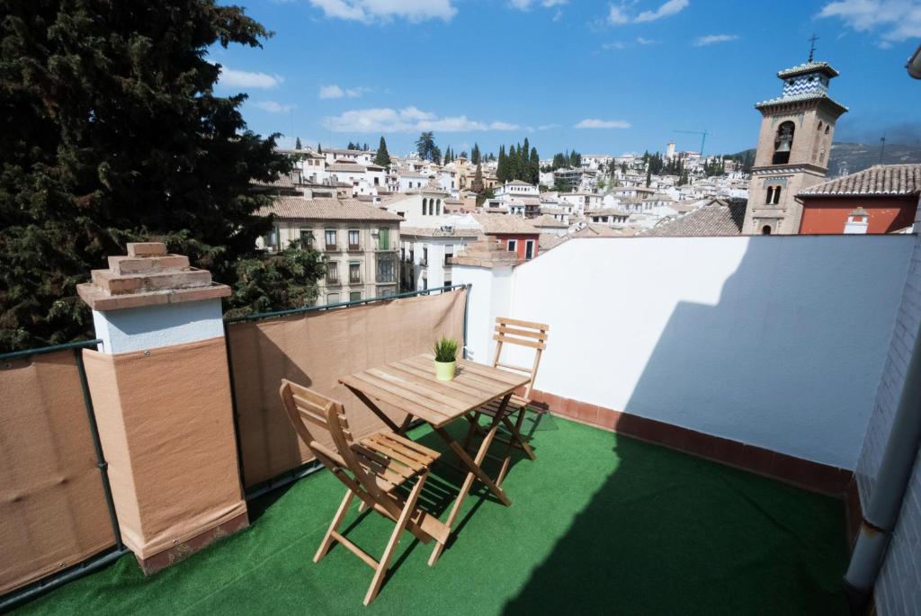 un patio con tavolo e sedie sul balcone. di APN Rio Darro a Granada