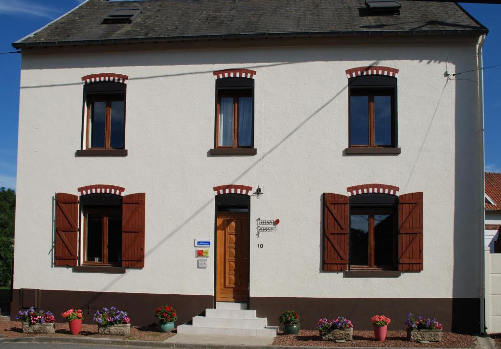 a white house with brown shuttered windows at The Silent Picket in Martinpuich