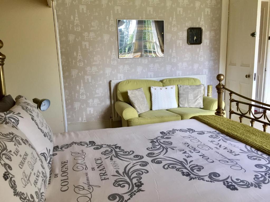 a bedroom with a bed and a couch at Gardenvale Manor House B&B in Stranocum
